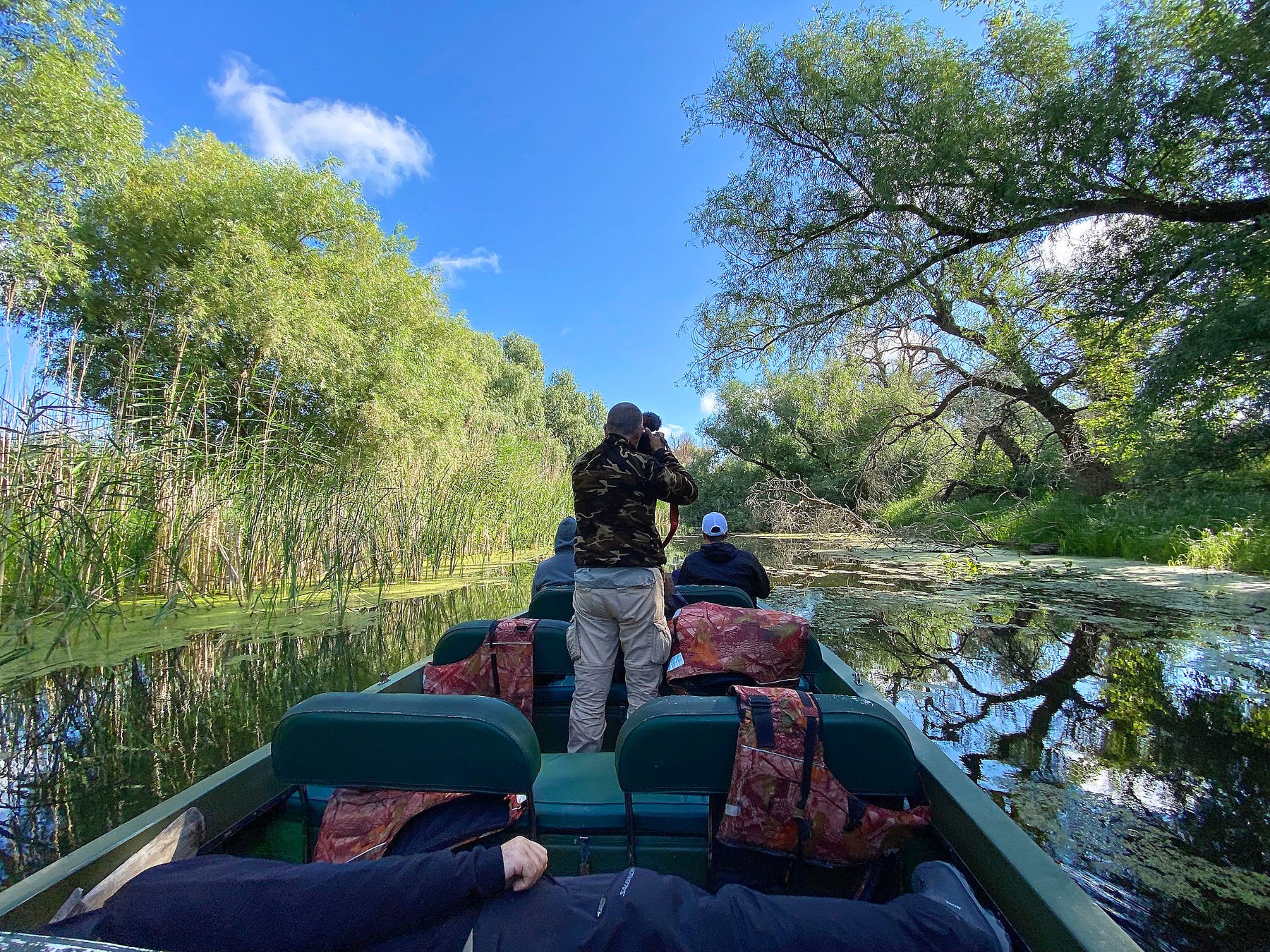 photographing from boat in forest channel romania